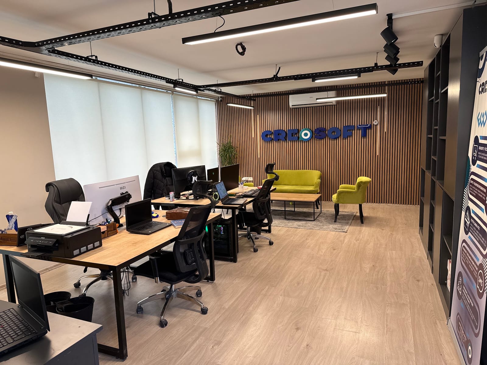AdPix ofisi: çalışma masaları, oturma köşesi ve duvardaki CreoSoft yazısı